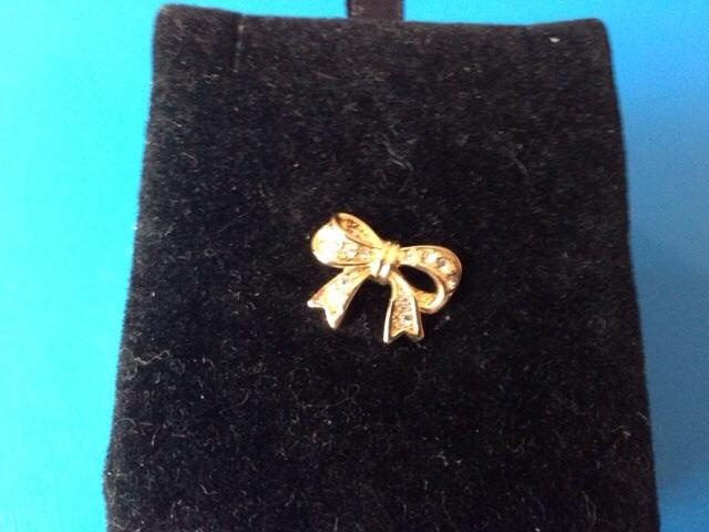 Preview of the first image of Small gold plated bow pin with clear stones.