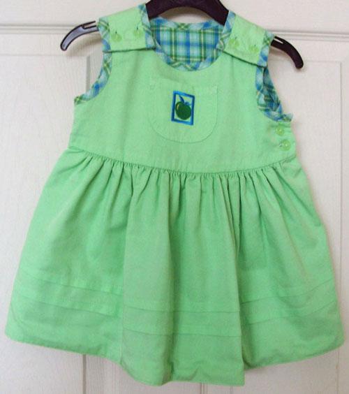 Preview of the first image of PRETTY BABY GIRLS REVERSIBLE GREEN DRESS - AGE 3/6 MTHS.