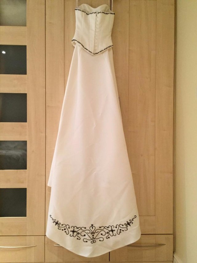 Preview of the first image of WEDDING DRESS (WHITE WITH BLACK DETAILING) AND UINDERSKIRT.