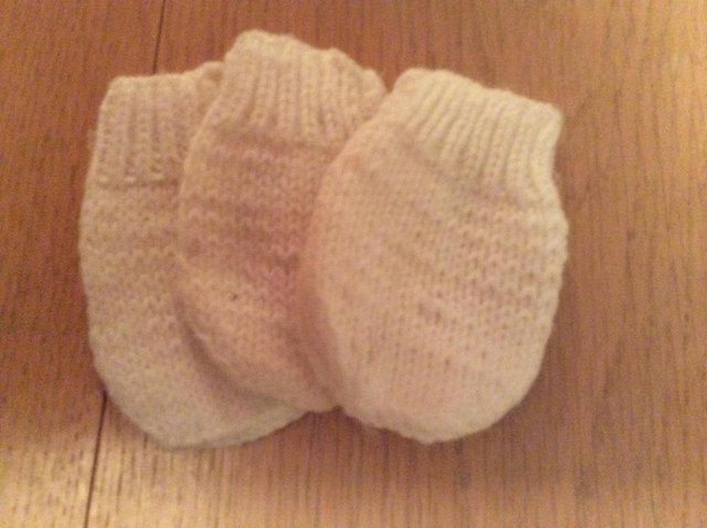 Preview of the first image of Three hand knitted  White baby wool mittens..