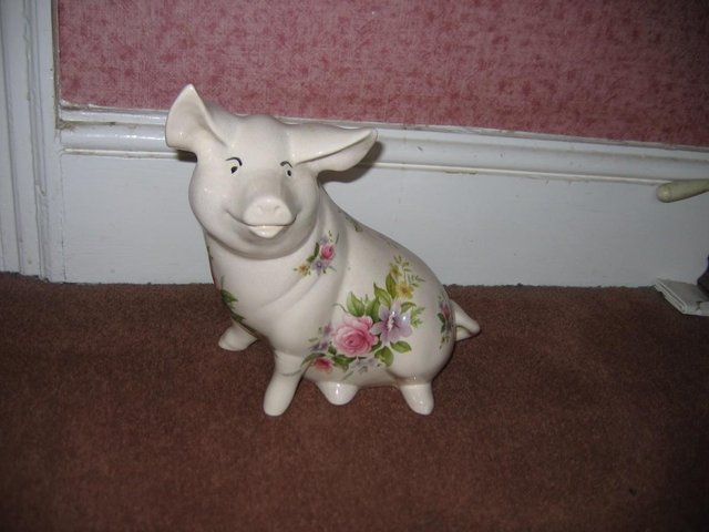 Preview of the first image of Vintage sitting Pottery pig floral pattern pretty but has cr.