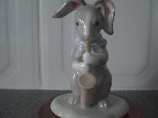 Preview of the first image of Porcelain Jazz quartet rabbit ornament on round wooden stand.