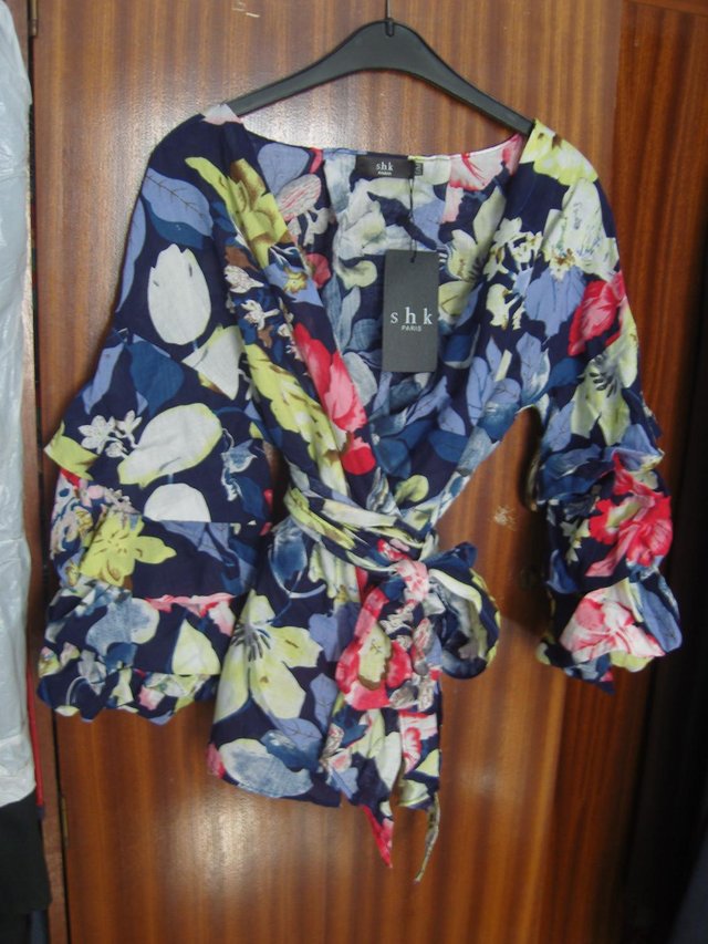 Preview of the first image of LADIES CROSSOVER/WRAP AROUND BLOUSE BRAND NEW AND UNWORN.
