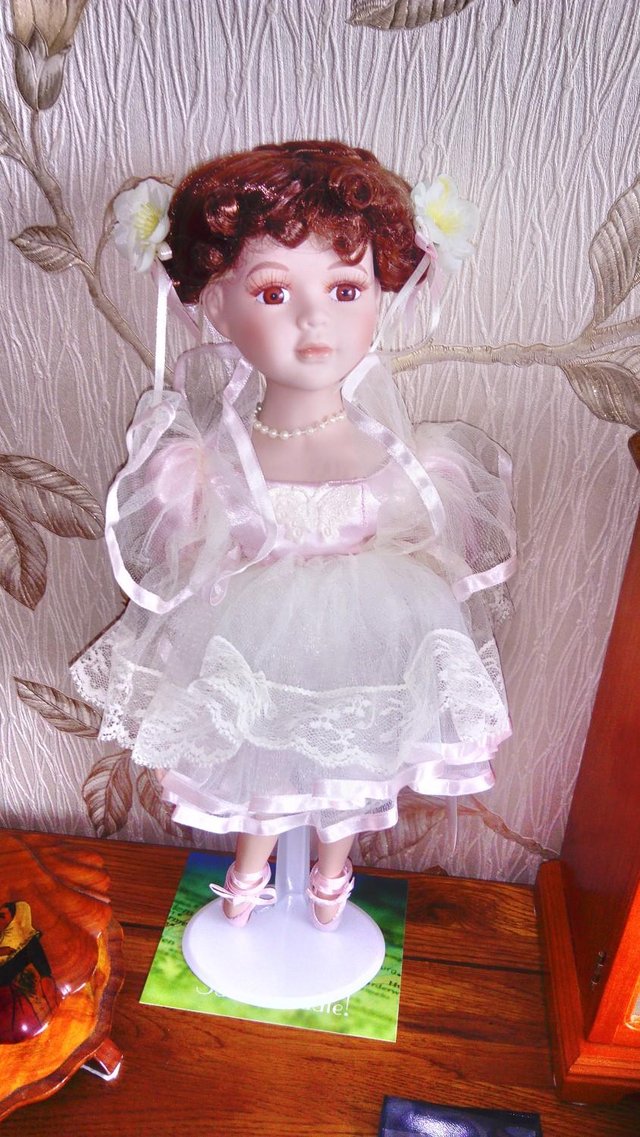 Preview of the first image of Collectible doll in a cream dress.