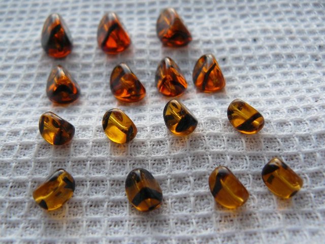 Preview of the first image of 15 antique amber/black stripe glass tiger beads Mixed sizes.