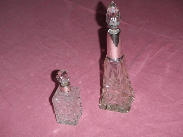 Preview of the first image of 2 glass scent bottles with silver neck collars and stoppers.