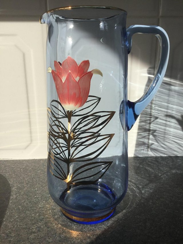 Preview of the first image of Attractive Blue Tint Glass Jug with two flowers.