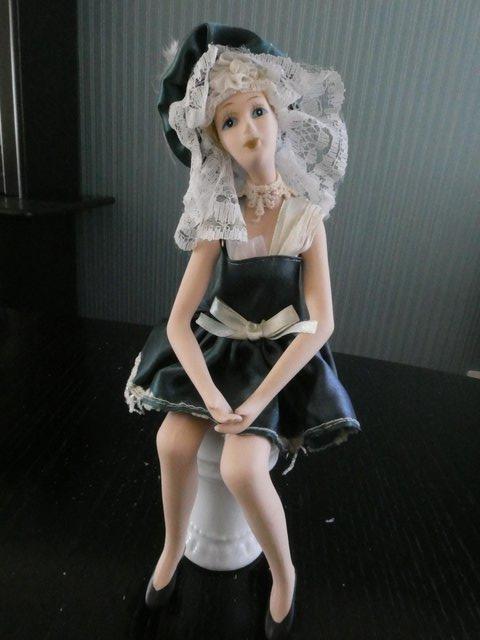 Preview of the first image of Antique articulated china painted doll on pedastal seat.
