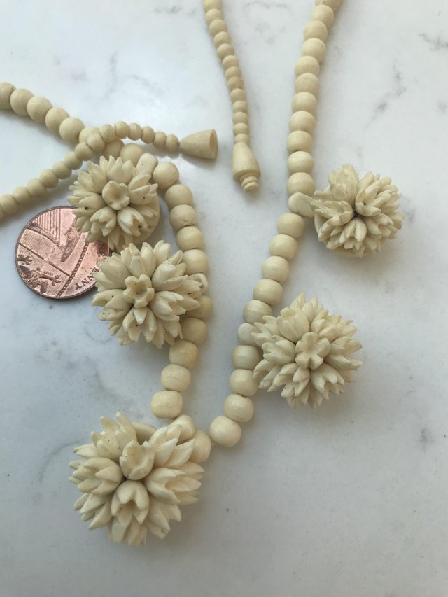 Preview of the first image of Carved bone (?) tribal necklace flowers 19” approx.