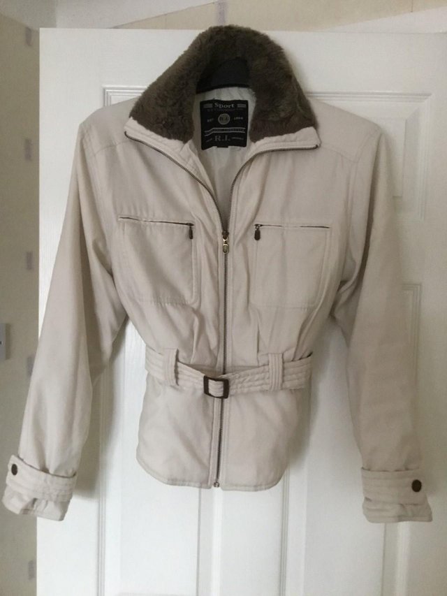Preview of the first image of River Island cream light weight jacket with belt.